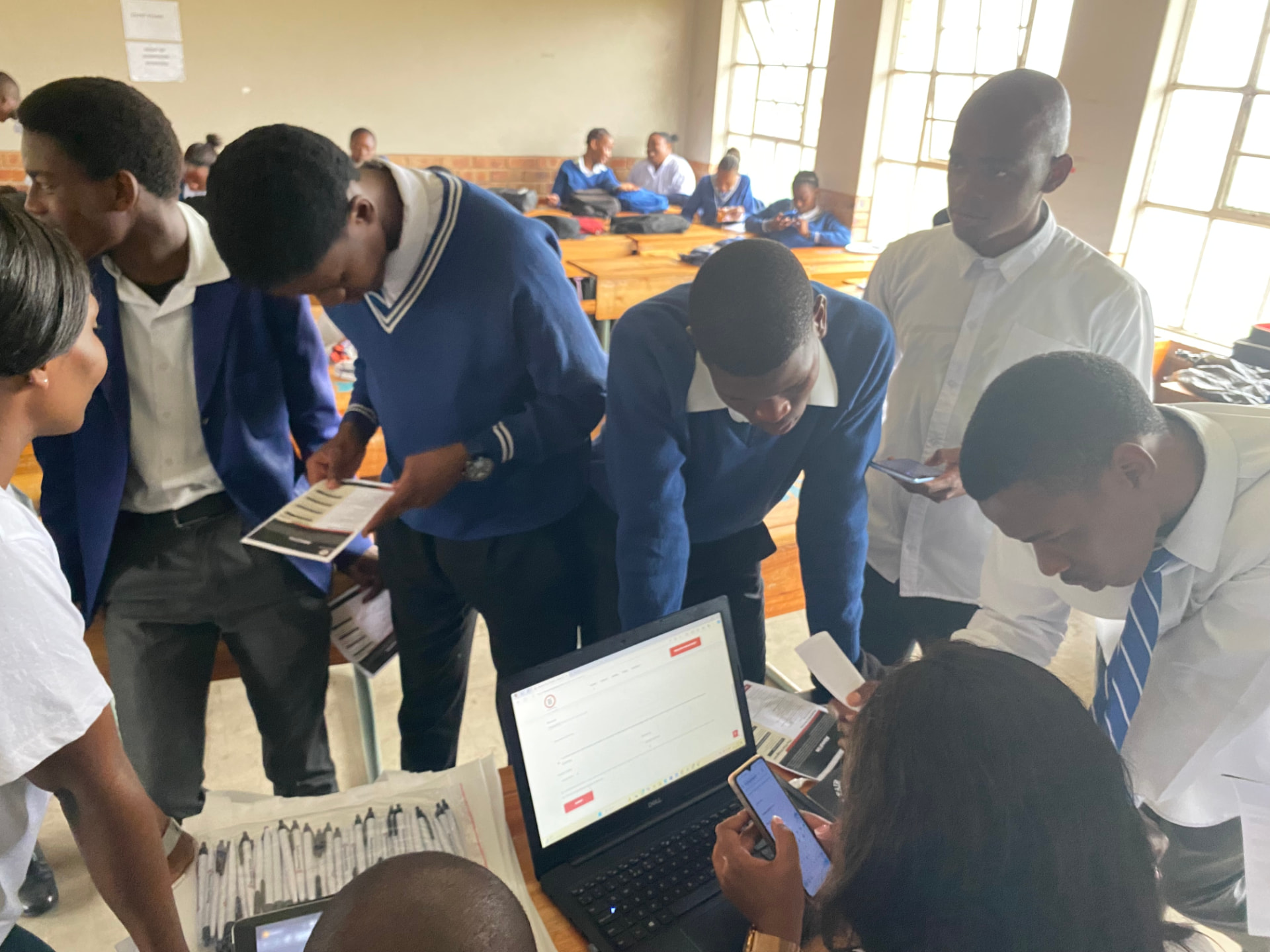 Students exploring the RI Experts platform on laptop and mobile at a career fair